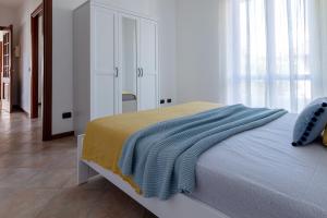 Un dormitorio con una cama con una manta azul. en Profumodilago, en Angera