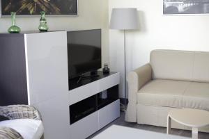 - un salon avec un canapé et une télévision dans l'établissement La parenthèse, à Dijon