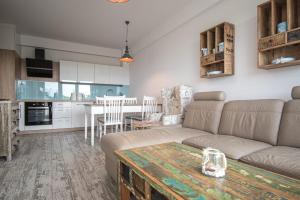 un salon avec un canapé et une table dans l'établissement Apartament na wydmie - Darłowo, à Darłowo 7 autres photos