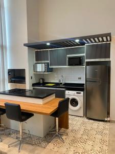 uma cozinha com uma mesa de madeira e um frigorífico em Departamento de lujo tipo dúplex em Ciudad del Este