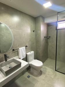 a bathroom with a toilet and a sink and a shower at Departamento de lujo tipo dúplex in Ciudad del Este