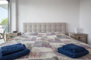 a bed with two blue pillows on top of it at Apartament na wydmie - Darłowo in Darłowo