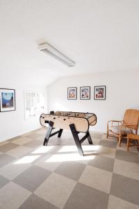 a ping pong table in a room with paintings at Gîte de groupe "La Donaclaudré" pour vos événements en pleine nature - 15 à 120 personnes proche de Disneyland Paris in Saint-Augustin