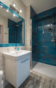 a bathroom with a sink and a shower at Apartament na wydmie - Darłowo in Darłowo