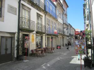 una mujer caminando por una calle de la ciudad con edificios en Apartamentos Valdemar, en Viana do Castelo