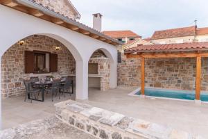 a patio with a table and chairs and a swimming pool at Holiday Home Rakova in Gornje Selo