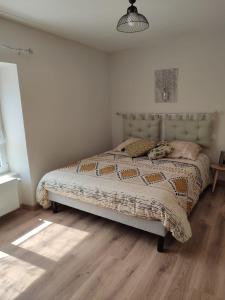 ein Schlafzimmer mit einem Bett in einem weißen Zimmer in der Unterkunft Gîte Les Tongs des Près, au cœur du Parc Normandie Maine in Livaie