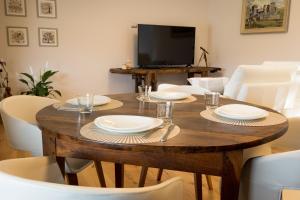 Una mesa de comedor con platos y vasos encima. en La Rose du Prevot, en Fenis