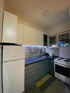 a kitchen with white cabinets and a white refrigerator at Apartment in Shtip in Štip
