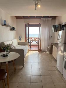 a living room with a couch and a table and a kitchen at Seafront Family Apartment Ellie in Skala Fourkas