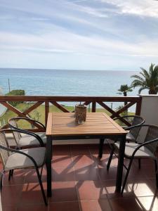 a table and chairs on a balcony with the ocean at Seafront Family Apartment Ellie in Skala Fourkas