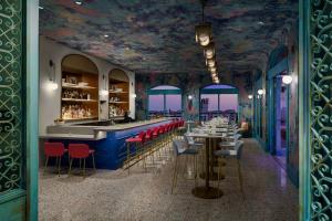 a restaurant with a blue bar with red chairs at AC Hotel St Petersburg Downtown in St Petersburg
