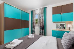 a bedroom with a bed with blue and brown cabinets at SkyRiver in Rijeka