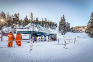 Due persone in piedi nella neve accanto a un impianto di risalita di Tranquil Haven Retreat - DSTR1068 a Stateline