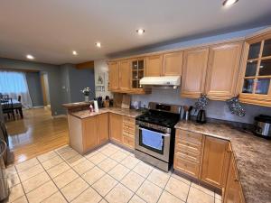 a kitchen with wooden cabinets and a stove top oven at Spacious private room near Finch station in Toronto