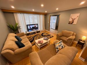sala de estar con 2 sofás y TV de pantalla plana en Spacious private room near Finch station en Toronto
