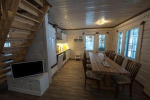 a dining room with a wooden table and a television at Wellamo in Syöte
