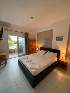 a bedroom with a large bed and a balcony at NAKOU FREIDERIKI ANTHOUSA PARGAs in Parga