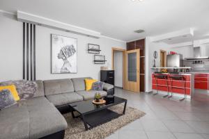 a living room with a couch and a kitchen at SkyRiver in Rijeka