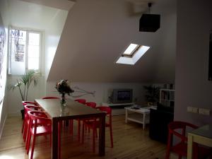 uma sala de estar com uma mesa e cadeiras vermelhas em Sincerely Lisboa em Lisboa