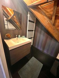 a bathroom with a sink and a wooden ceiling at Burgemeestershof in Wetteren