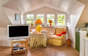 - un salon avec une télévision et une chaise dans l'établissement 4 Bedroom Beautiful Home In Eskilstuna, à Sundby