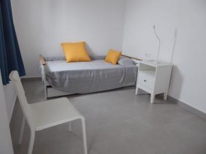 ein Wohnzimmer mit einem Sofa, einem Tisch und einem Stuhl in der Unterkunft La casa rosada (The pink house) in Tejina