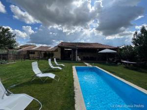 a yard with a pool with chairs and a house at White Tree JARA - Casa Rural para grupos con piscina en Zamora in Rabanales