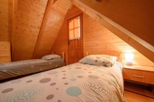 1 dormitorio con 1 cama en una cabaña de madera en Domki nad morzem - Nevada en Darlowko