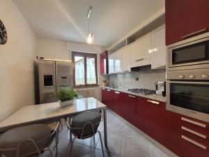 a kitchen with red cabinets and a table with chairs at A Rimirar il Lago Mountain Lake Iseo Hospitality in Bossico