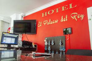 een kantoor met een rode muur met een hotelbord bij Hotel El Palacio Del Rey in Duitama