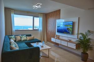 a living room with a blue couch and a tv at Tanger City Center Residences Suites & sea view in Tangier