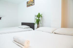 two beds sitting next to each other in a room at Hotel El Palacio Del Rey in Duitama