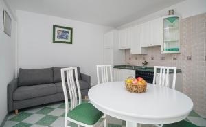 a white kitchen with a table and a couch at Villa David in Vodice +14 photos