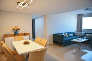 a living room with a couch and a table and chairs at Tanger City Center Residences Suites & sea view in Tangier
