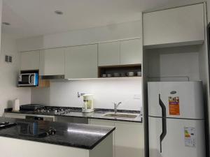 una cucina con armadietti bianchi e frigorifero di Adrogué Apartments, zona céntrica de Adrogué a Adrogué