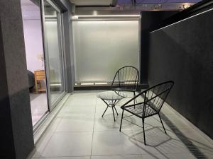 2 sillas y una mesa en una habitación en Adrogué Apartments, zona céntrica de Adrogué en Adrogué