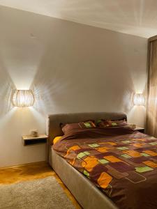 a bedroom with a bed and two lights on the wall at Apartment in Shtip in Štip
