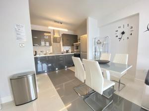 a kitchen and dining room with a table and chairs at Contemporary City Centre Apartment in The Aspect in Cardiff