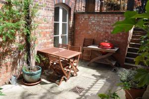 a patio with a wooden table and a table and a chair at Two Elegant Victorian Apartments 1BR & 2BR in Cheltenham, Cotswolds - Sleeps 10 - FREE Parking in Cheltenham