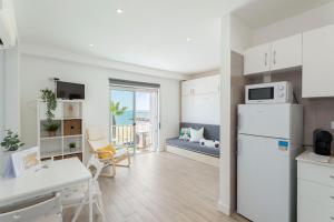 cocina y sala de estar con nevera blanca en Stunning Studio with Beach Front- Astro Quarteira by Centralgarve en Quarteira