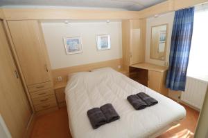アルネマイデンにあるHof Nieuwerkerk Chalet 2のベッドルーム1室(ベッド1台、タオル2枚付)
