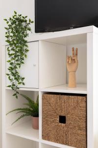 a white cabinet with a tv and a plant at Stunning Studio with Beach Front- Astro Quarteira by Centralgarve in Quarteira