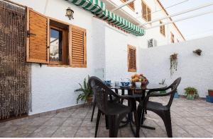 a patio with a table with chairs and fruit on it at Casa Merche in San José