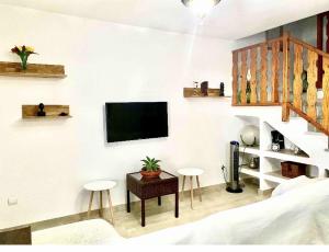 a bedroom with a tv on a wall with stools at Casa Merche in San José