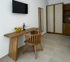 a wooden table with a television and a wooden chair at La Villa Rooms in Mikonos +17 photos