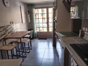 a kitchen with two tables and two stools in it at L'Astré in Loupian