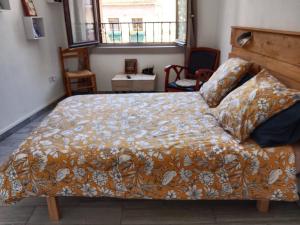 a bedroom with a large bed with an orange blanket at L'Astré in Loupian