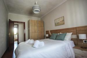 a bedroom with a large white bed with towels on it at Aurrekoetxea 36 VR, Talako Izarra in Bermeo