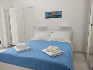 a bedroom with a blue bed with towels on it at Sea Moon Apartment in Bari